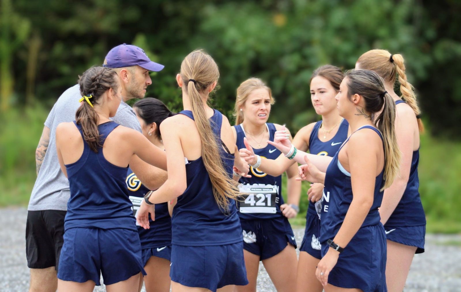 Gaston College women's cross country coach Kody Kubbs (grey shirt) talks to his Rhinos' team just before they run in Saturday's Yetis Invitational in Shelby.